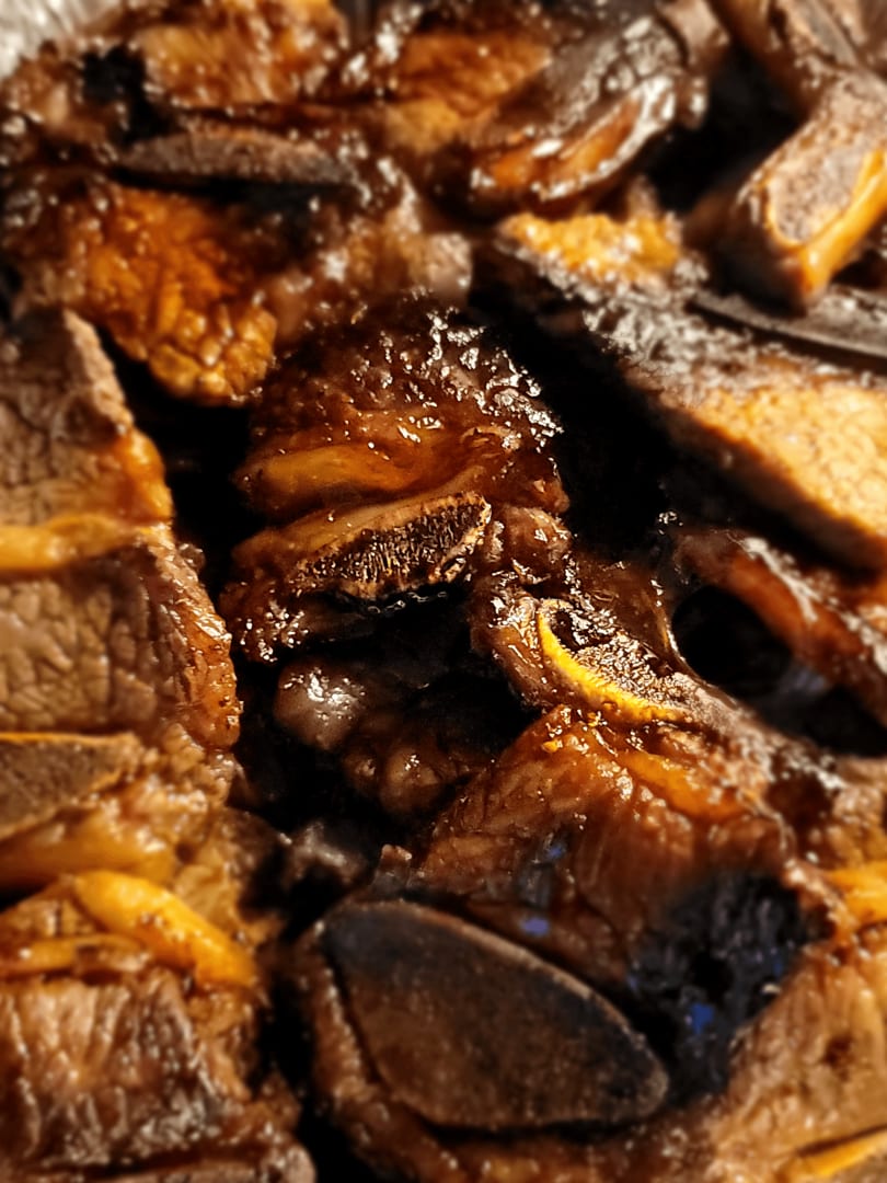 Close-up of Mama Dukes Hawaiian Barbeque short ribs, glistening with sauce and tender meat.